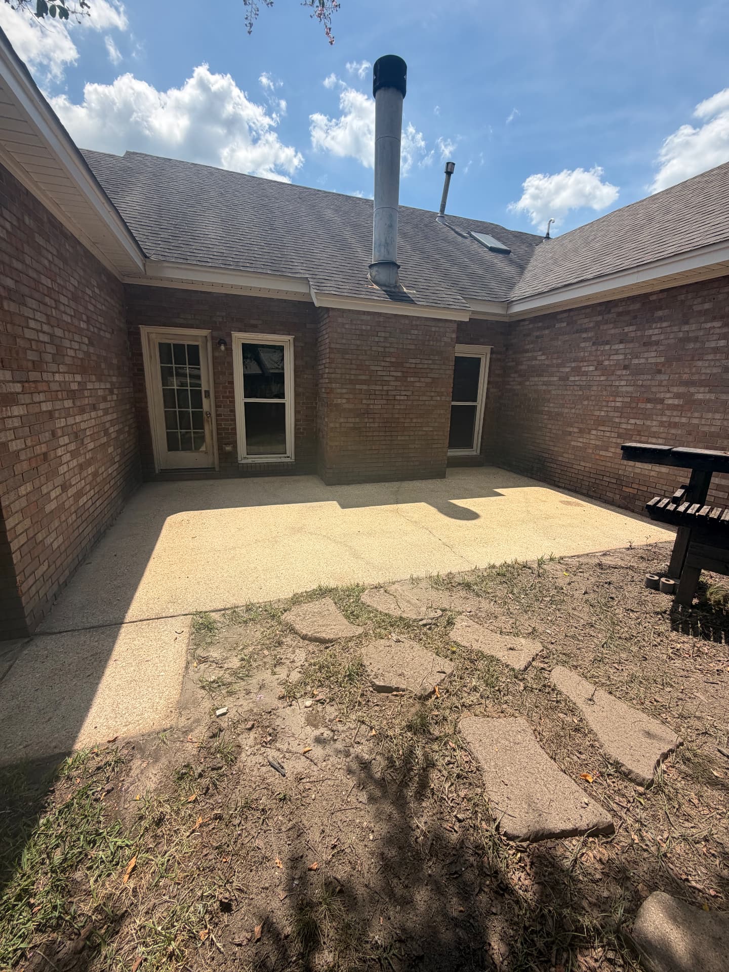 Same back patio after pressure washing, concrete restored to a light tan